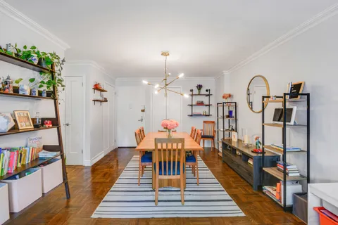 a view of a hallway with furniture and wooden floor