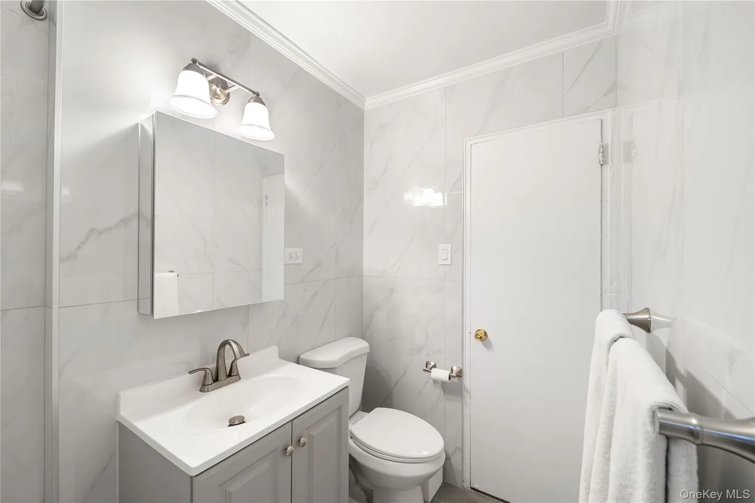 a bathroom with a toilet a sink a mirror and vanity