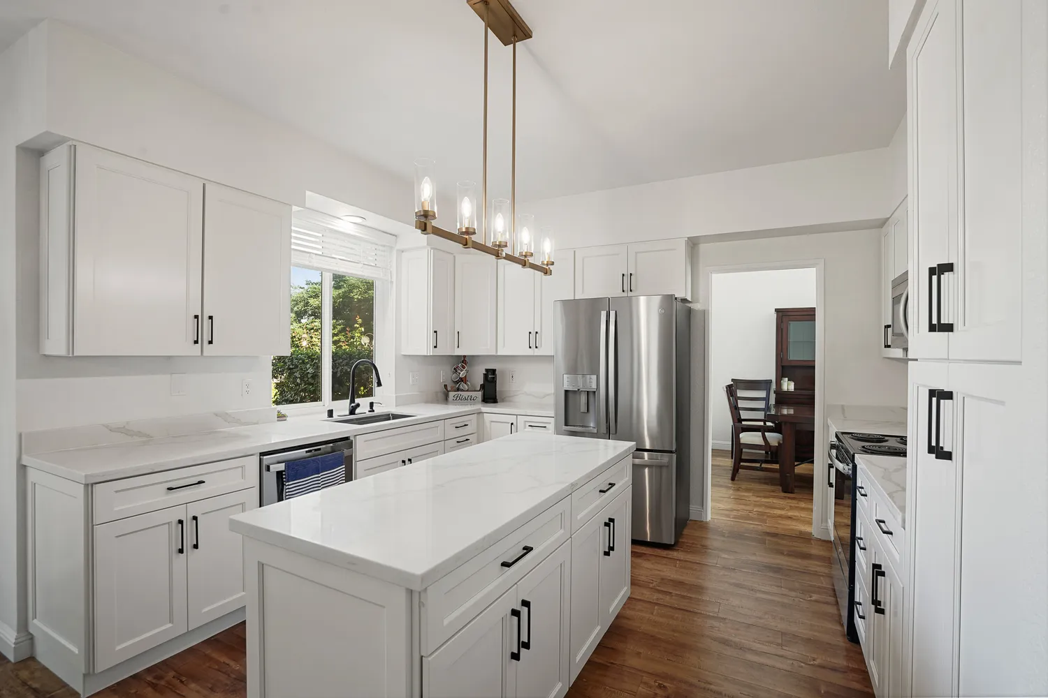 a kitchen with a refrigerator a sink and wooden floor