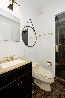845 United Nations Plaza, Unit 56E Manhattan, NY 10017 - Photo 17 of 28 a bathroom with a granite countertop toilet sink and mirror