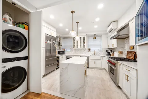 a kitchen with white cabinets and stainless steel appliances