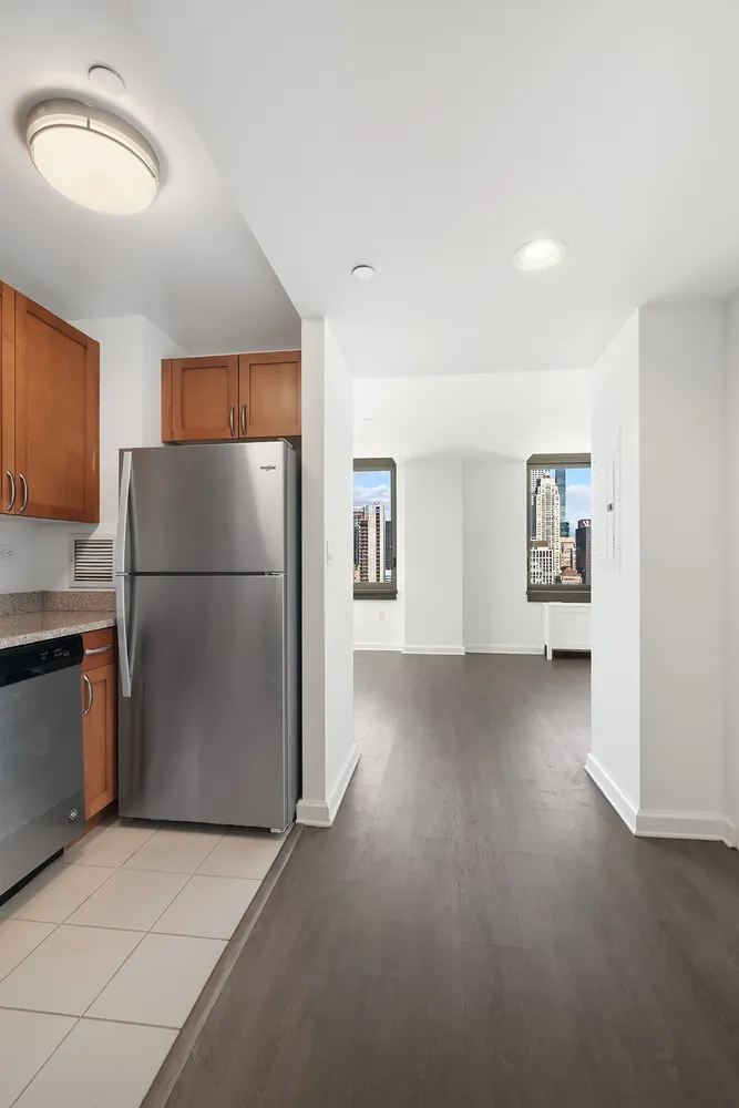 a view of a refrigerator in kitchen and a windows