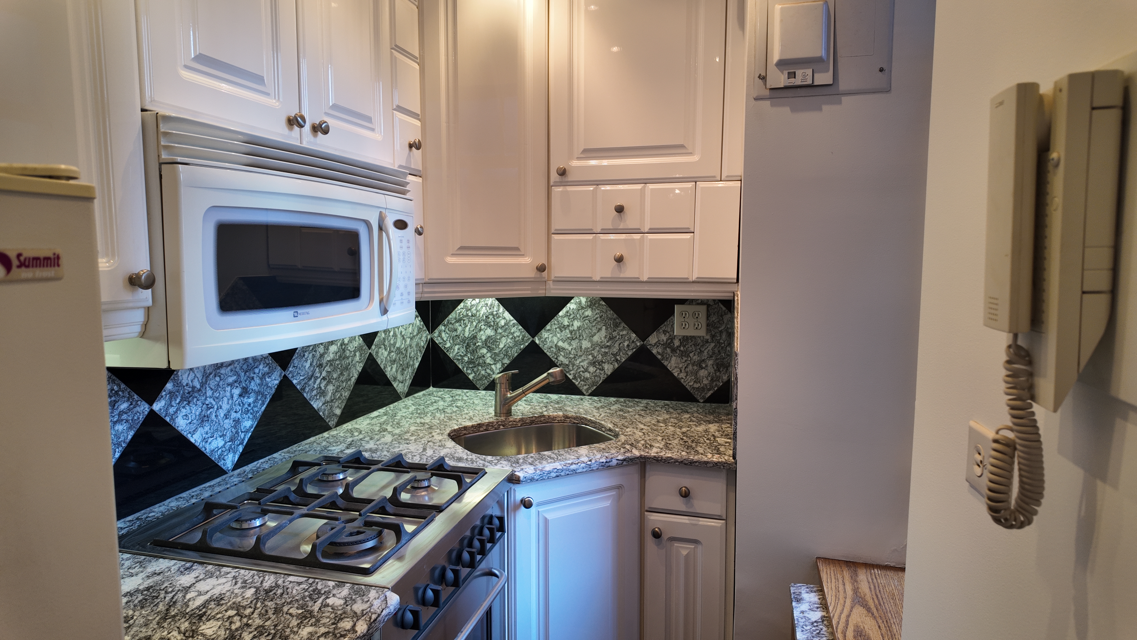 750 Park Avenue, Unit 8D Manhattan, NY 10021 - Photo 9 of 14 a kitchen with stainless steel appliances granite countertop a stove and a refrigerator