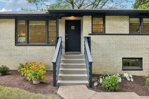 a front view of a house with potted plants