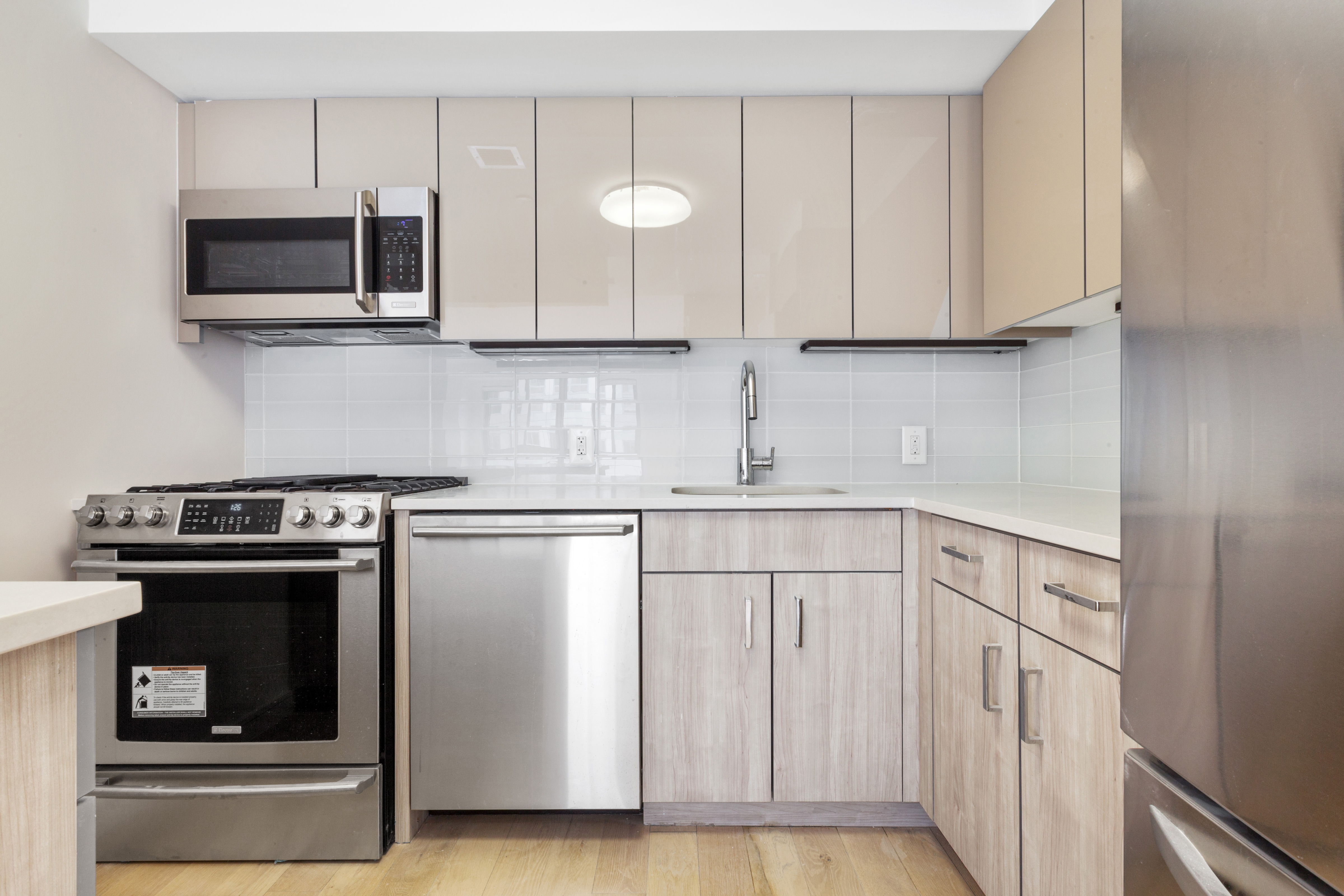 171 West 131st Street, Unit 517 Manhattan, NY 10027 - Photo 2 of 10 a kitchen with stainless steel appliances granite countertop white cabinets stove a sink and dishwasher
