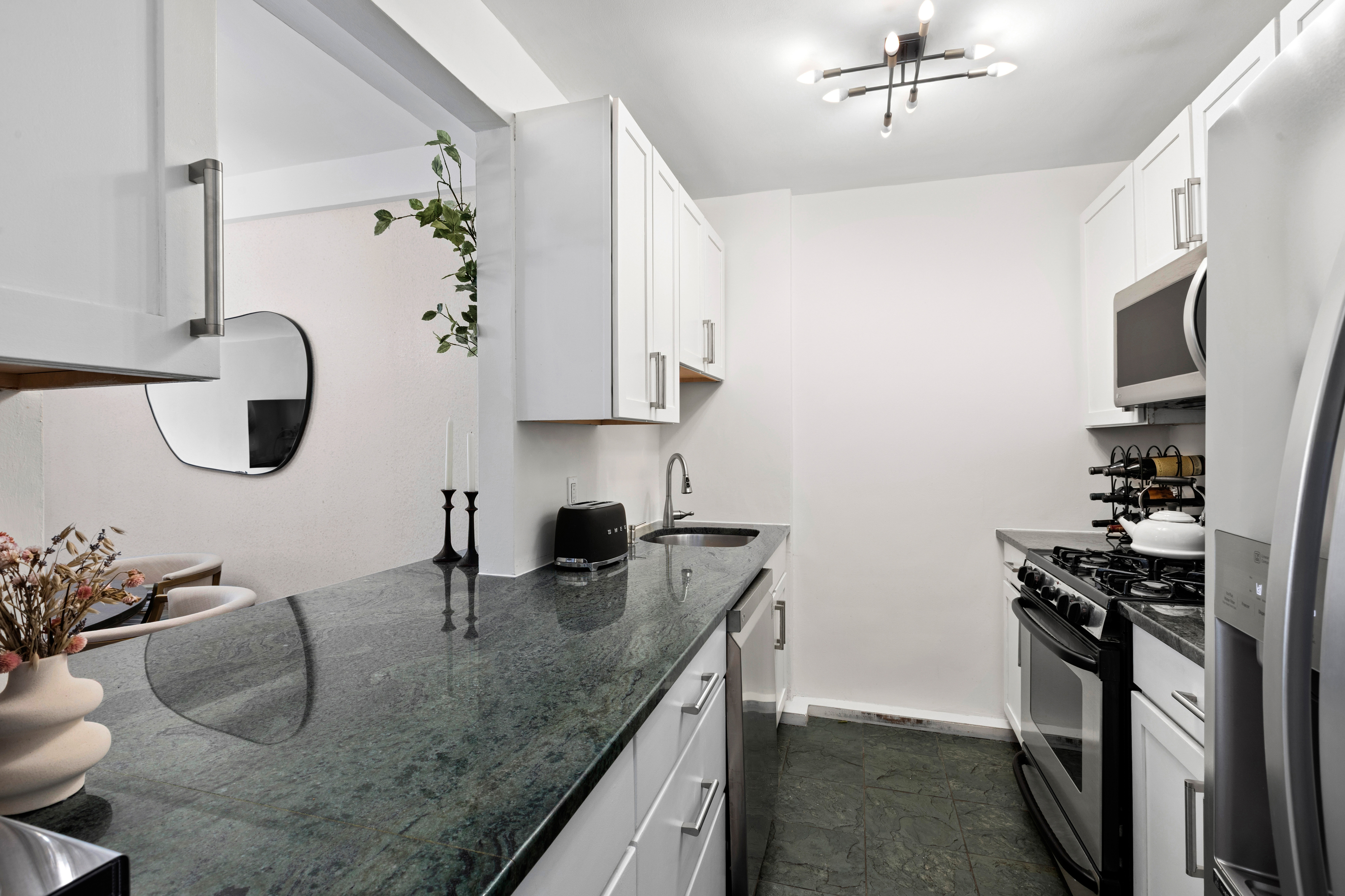 40 East 9th Street, Unit 7L Manhattan, NY 10003 - Photo 11 of 17 a kitchen with stainless steel appliances granite countertop a sink stove and refrigerator