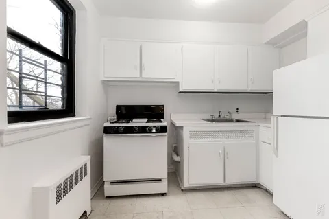 a kitchen with white cabinets and white appliances