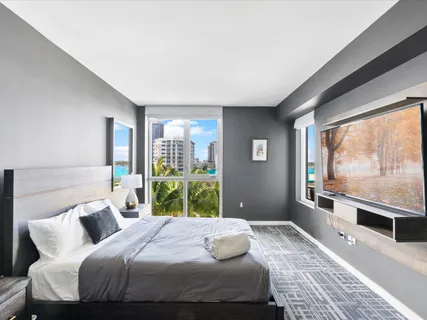 a bedroom with a bed and a large window