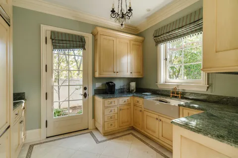 a kitchen with granite countertop a sink window and cabinets