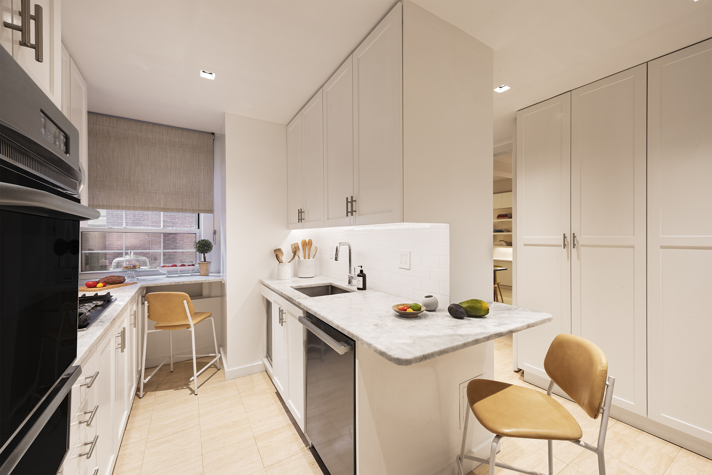 1070 Park Avenue, Unit 7D Manhattan, NY 10128 - Photo 7 of 14 a kitchen with a sink cabinets and chair