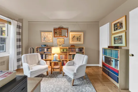 a living room with furniture and a book shelf