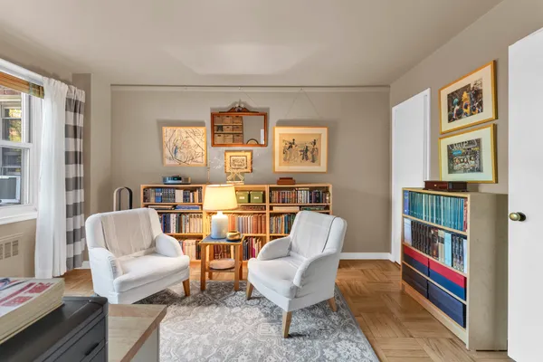 a living room with furniture and a book shelf