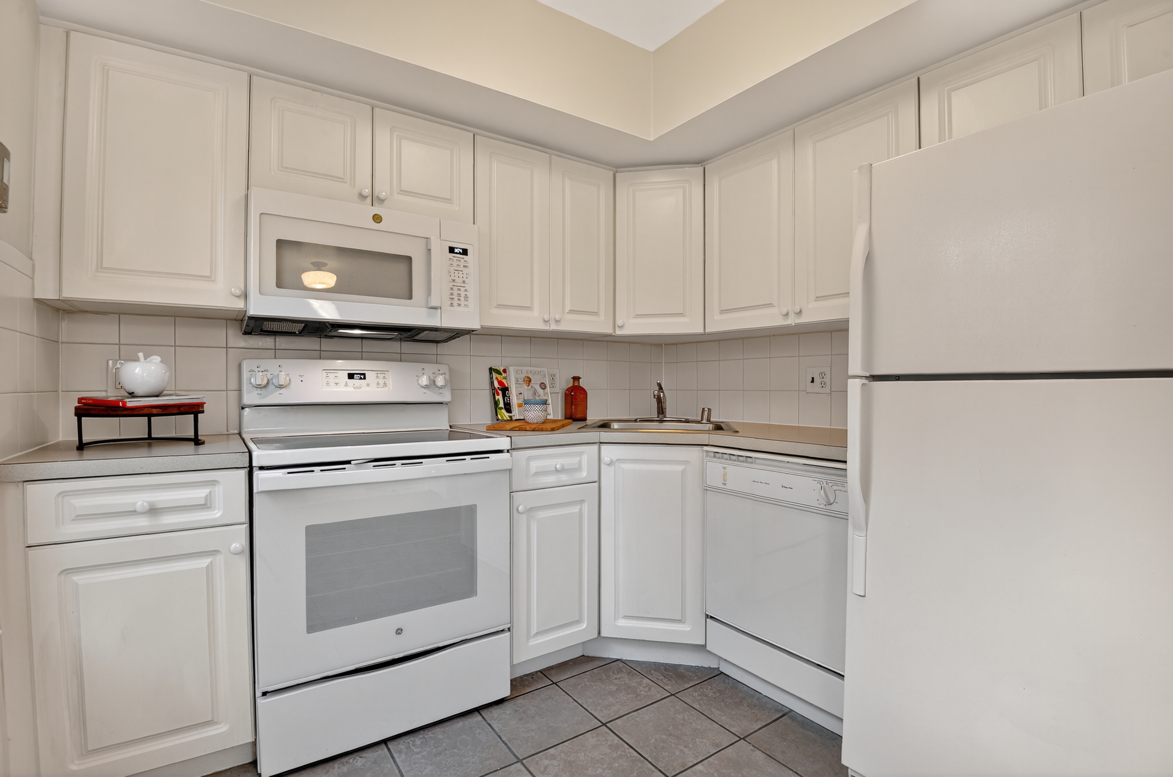 1493 15th Street Northeast, Unit 1493 Washington, DC 20002 - Photo 11 of 26 a kitchen with white cabinets and white appliances