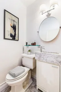 a bathroom with a toilet a sink and mirror