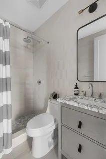 a bathroom with a sink a toilet and shower