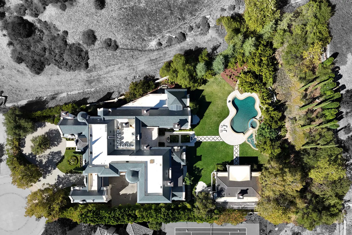 an aerial view of a house with a swimming pool and outdoor seating