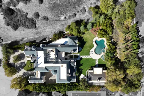an aerial view of a house with a swimming pool and outdoor seating