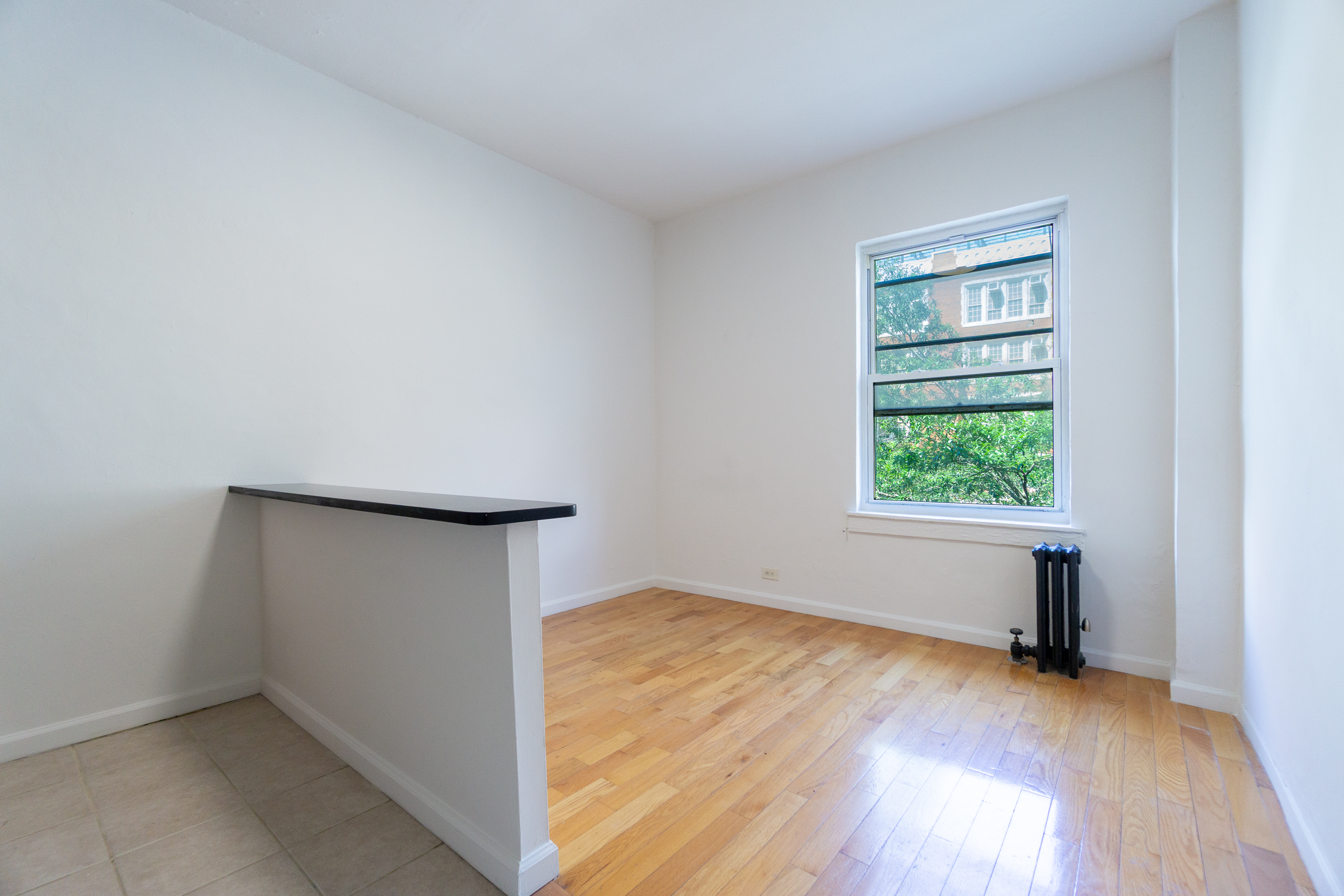 320 West 20th Street, Unit 15 Manhattan, NY 10011 - Photo 2 of 14 an empty room with wooden floor and windows
