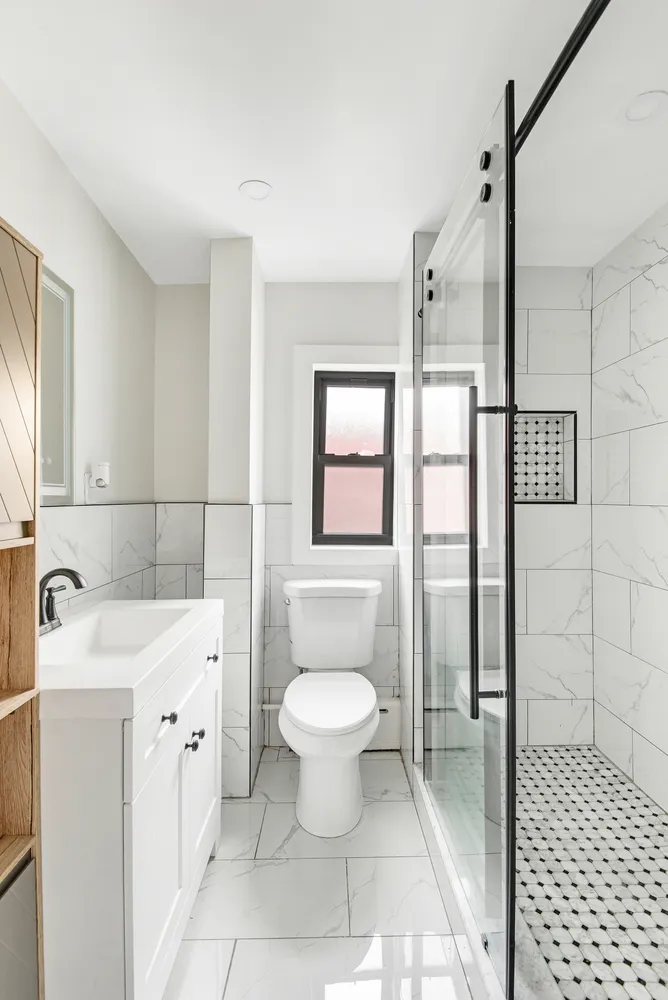 a bathroom with a sink a toilet and shower