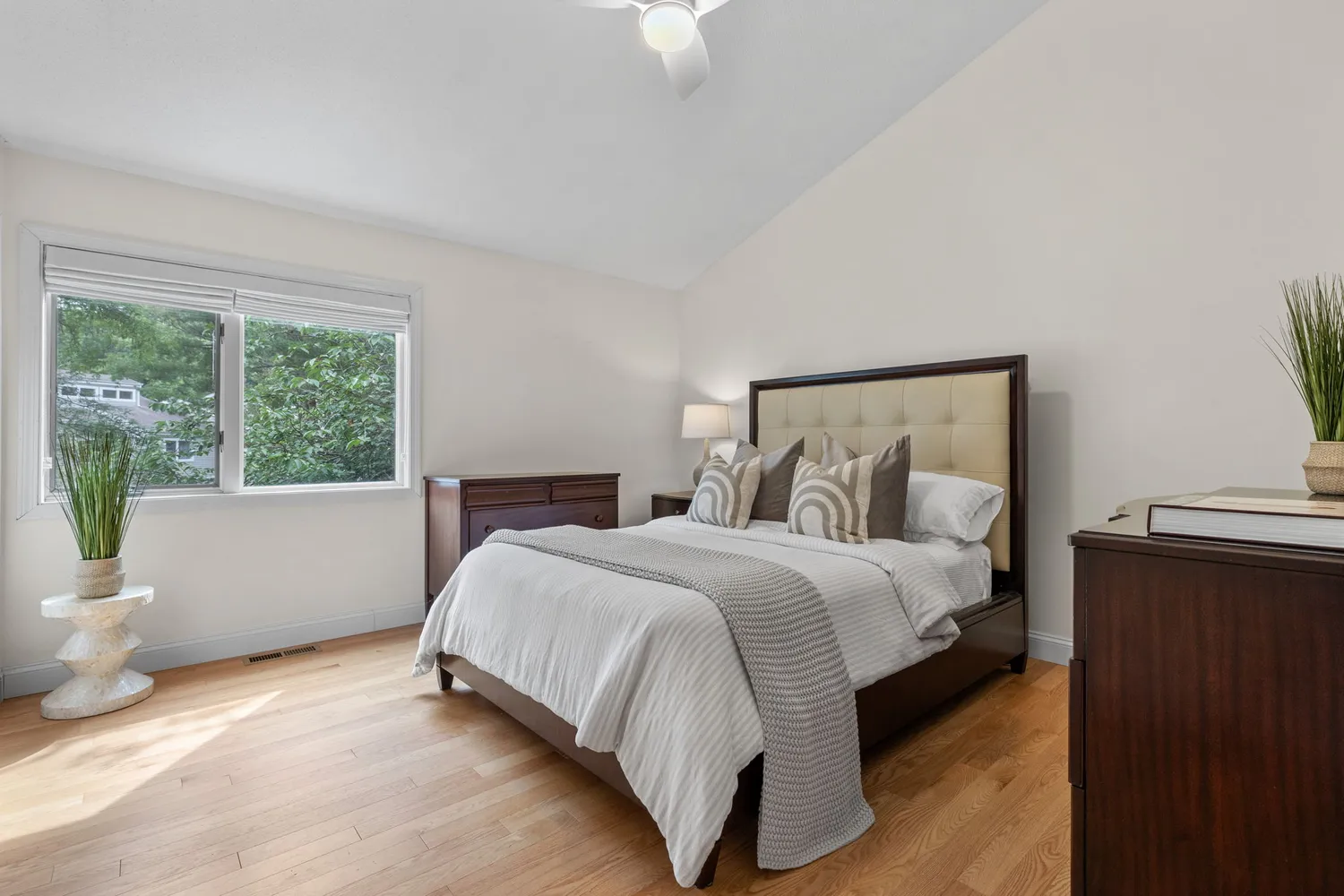 a large bed sitting in a bedroom next to a window