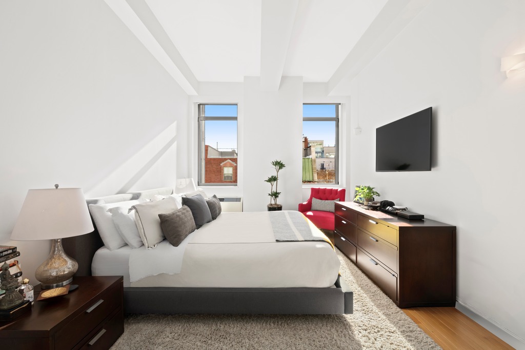 252 7th Avenue, Unit 10T Manhattan, NY 10001 - Photo 6 of 10 a bedroom with bed and flat screen tv
