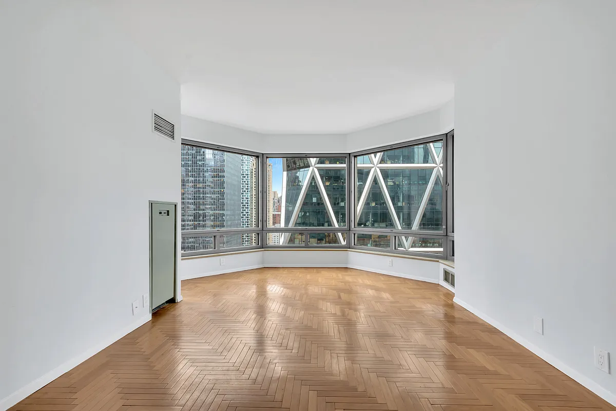 301 West 57th Street, Unit 22E Manhattan, NY 10019 - Photo 2 of 13 a view of empty room with wooden floor and fan