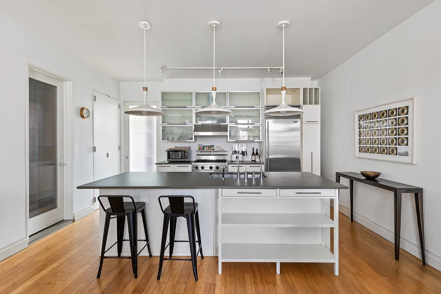 a kitchen with kitchen island granite countertop a table chairs sink and wooden floor