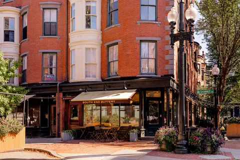 front view of a building with a lot of windows and plants