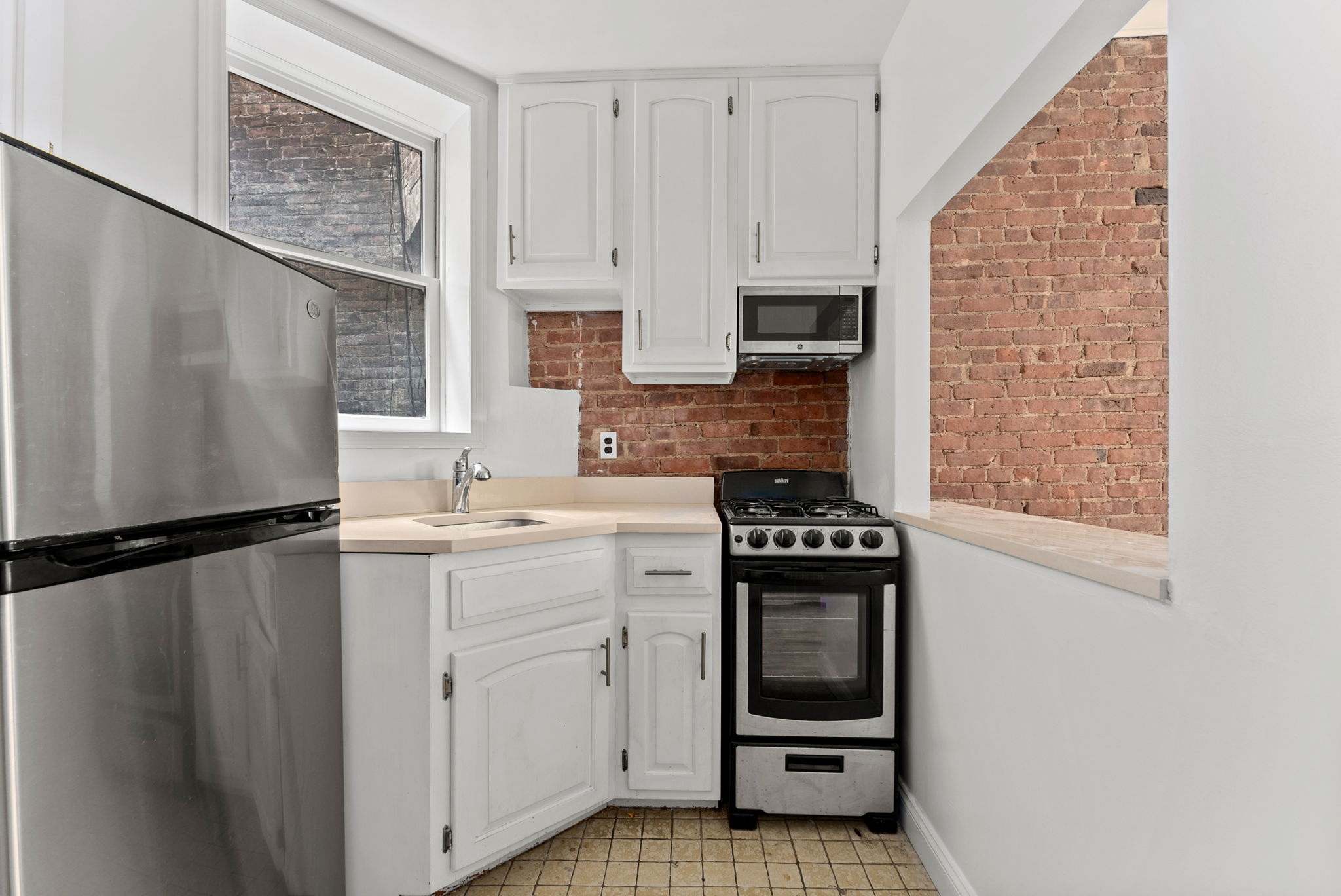 333 East 92nd Street, Unit 4A Manhattan, NY 10128 - Photo 3 of 5 a kitchen with a refrigerator stove and sink