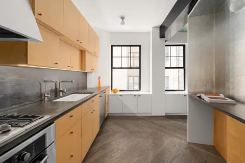 a kitchen with granite countertop a sink stove and cabinets