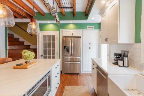 a kitchen with stainless steel appliances a sink a refrigerator and wooden cabinets