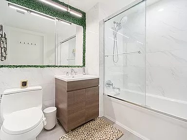 2351 Adam Clayton Powell Jr Boulevard, Unit 306 Manhattan, NY 10030 - Photo 4 of 13 a bathroom with a toilet a sink and a shower