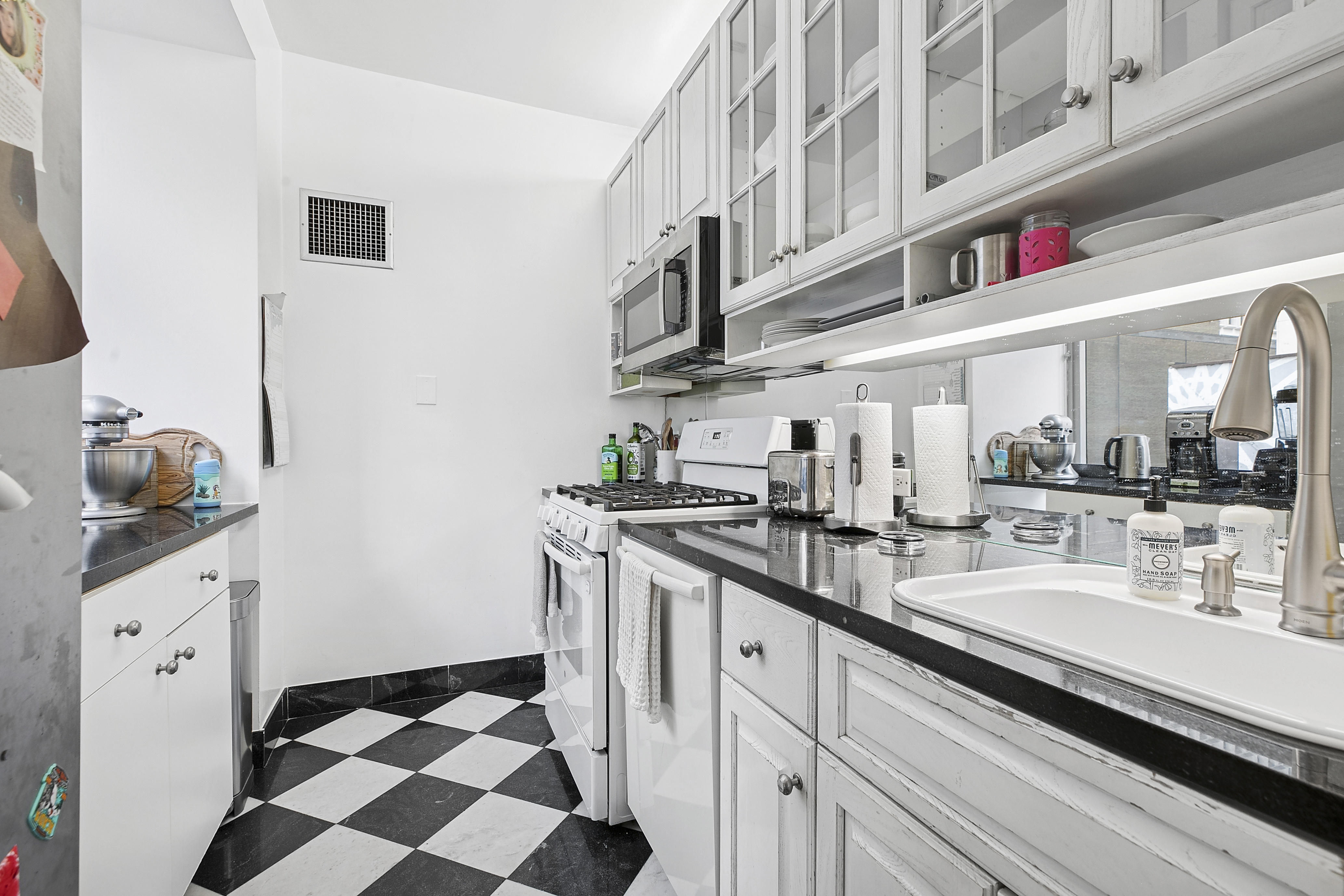 250 East 54th Street, Unit 6A Manhattan, NY 10022 - Photo 5 of 13 a kitchen with stainless steel appliances granite countertop a sink and cabinets