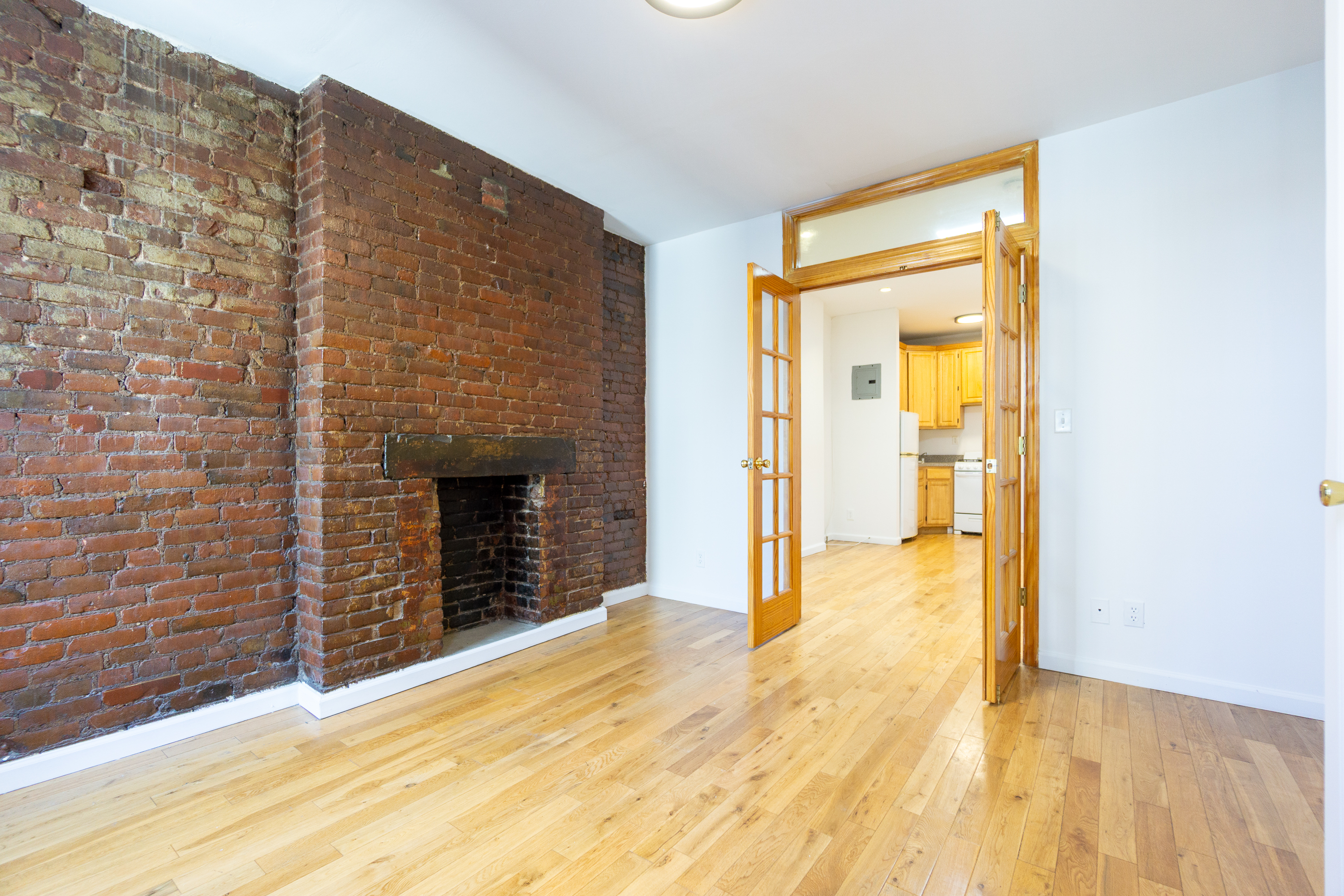339 East 6th Street, Unit 14 Manhattan, NY 10003 - Photo 4 of 8 a view of an empty room with a fireplace and a window