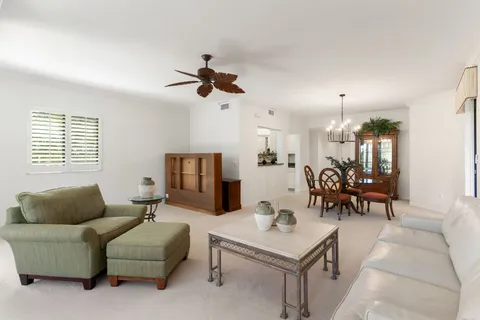 a living room with furniture kitchen view and a window