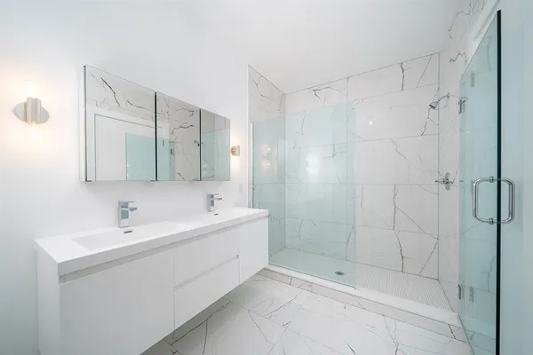 a bathroom with a shower sink and mirror