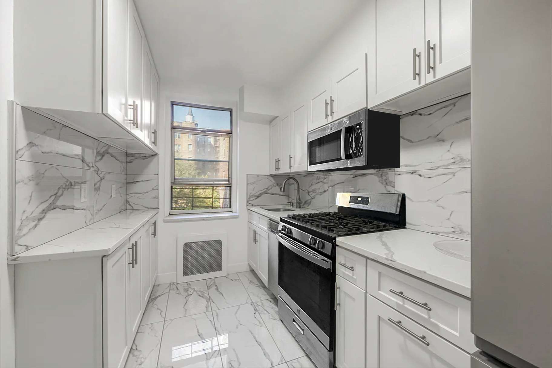 76-10 34th Avenue, Unit 2H Queens, NY 11372 - Photo 3 of 11 a kitchen with granite countertop a stove sink and microwave