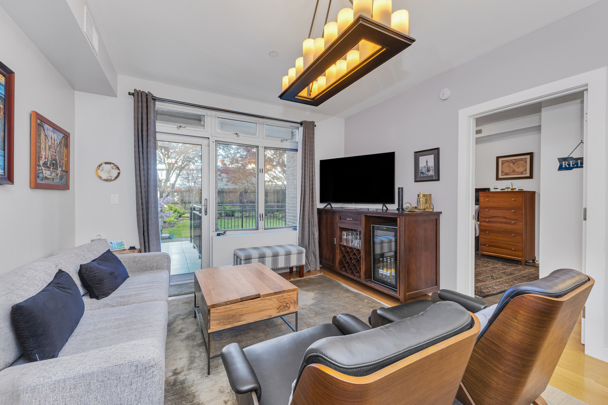 319 Humboldt Street, Unit 1B Brooklyn, NY 11211 - Photo 4 of 17 a living room with furniture a flat screen tv and a floor to ceiling window
