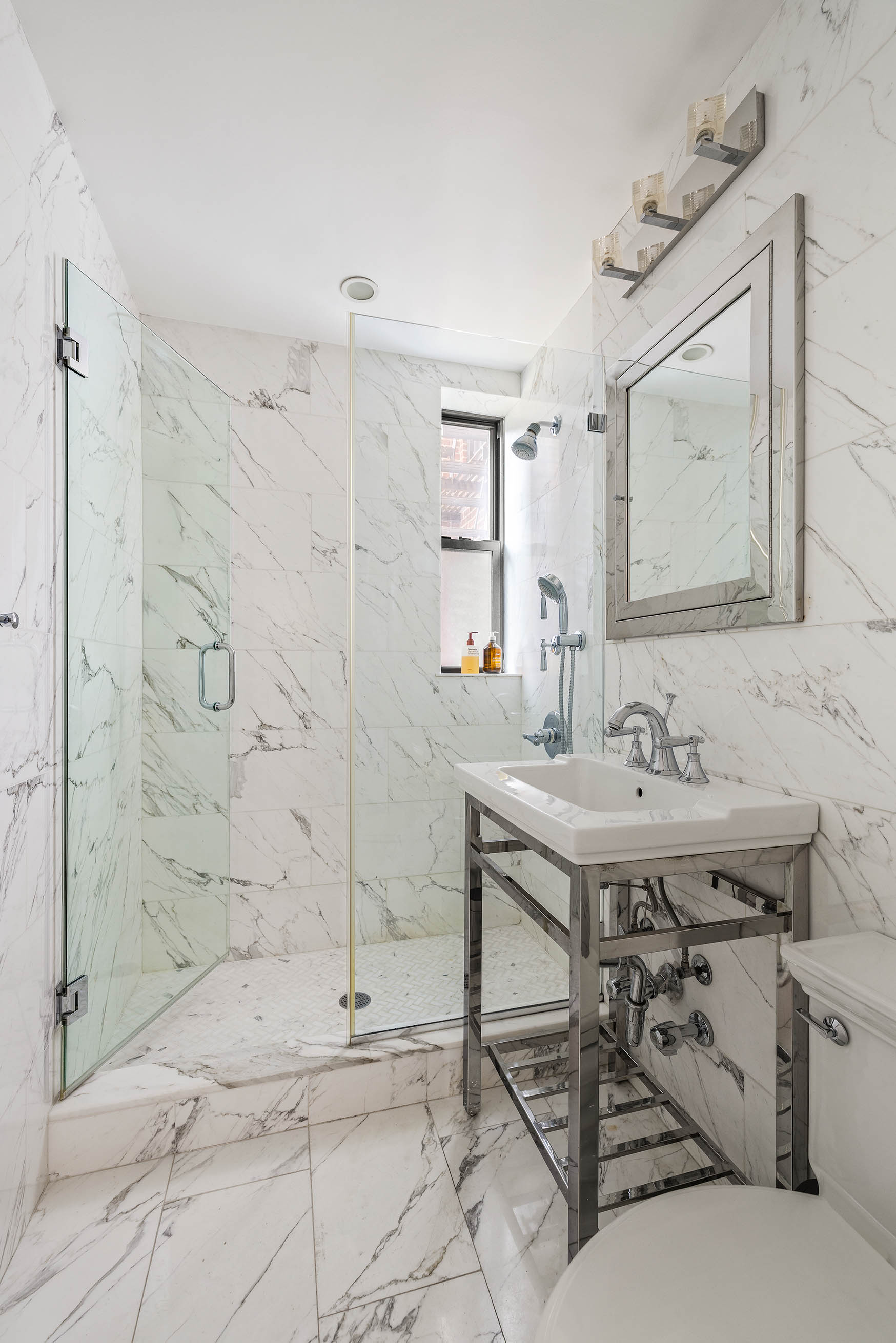 60 East 9th Street, Unit 211 Manhattan, NY 10003 - Photo 6 of 7 a bathroom with a sink and a mirror