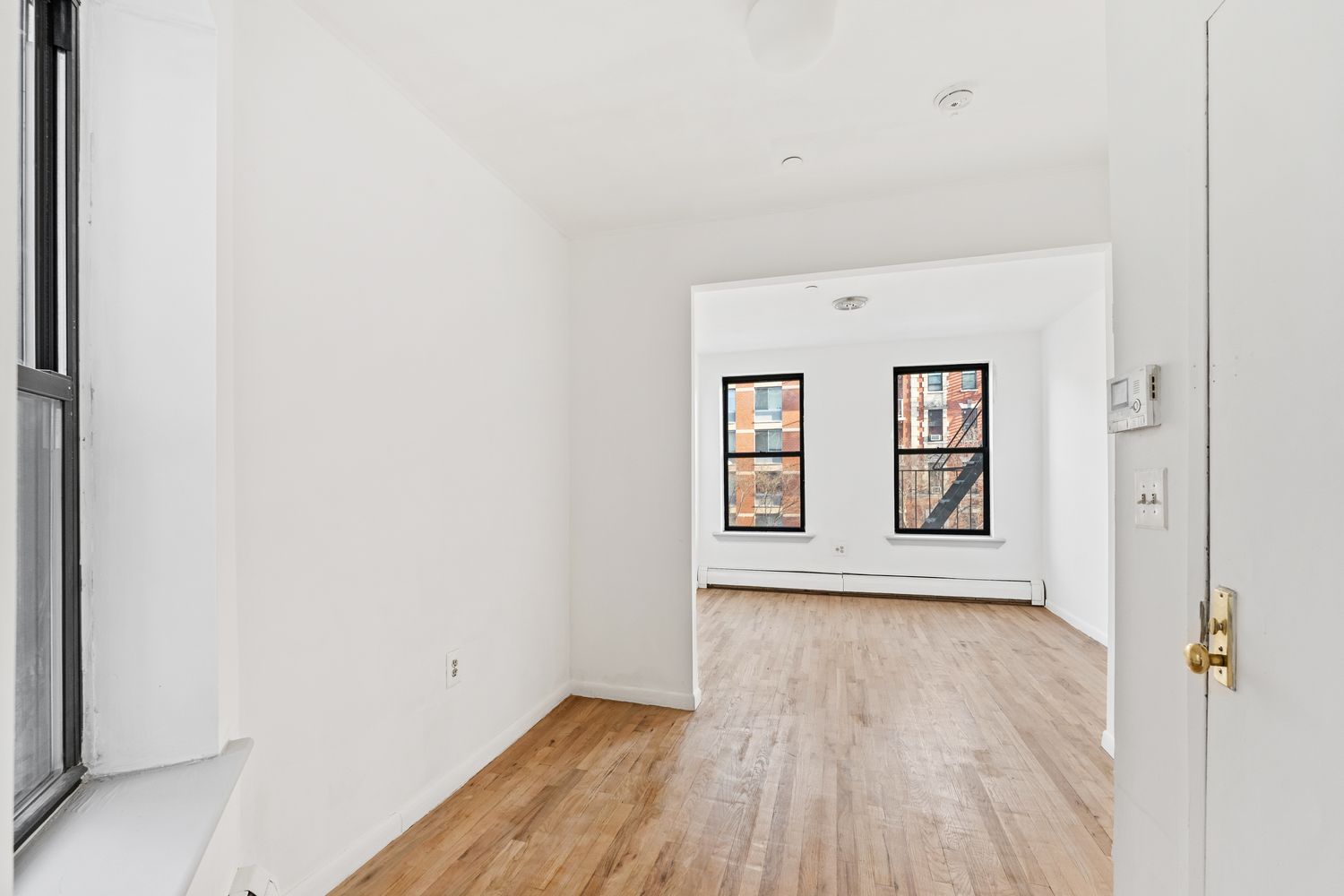 327 Pleasant Avenue, Unit 5B Manhattan, NY 10035 - Photo 2 of 5 a view of an empty room with wooden floor and a window