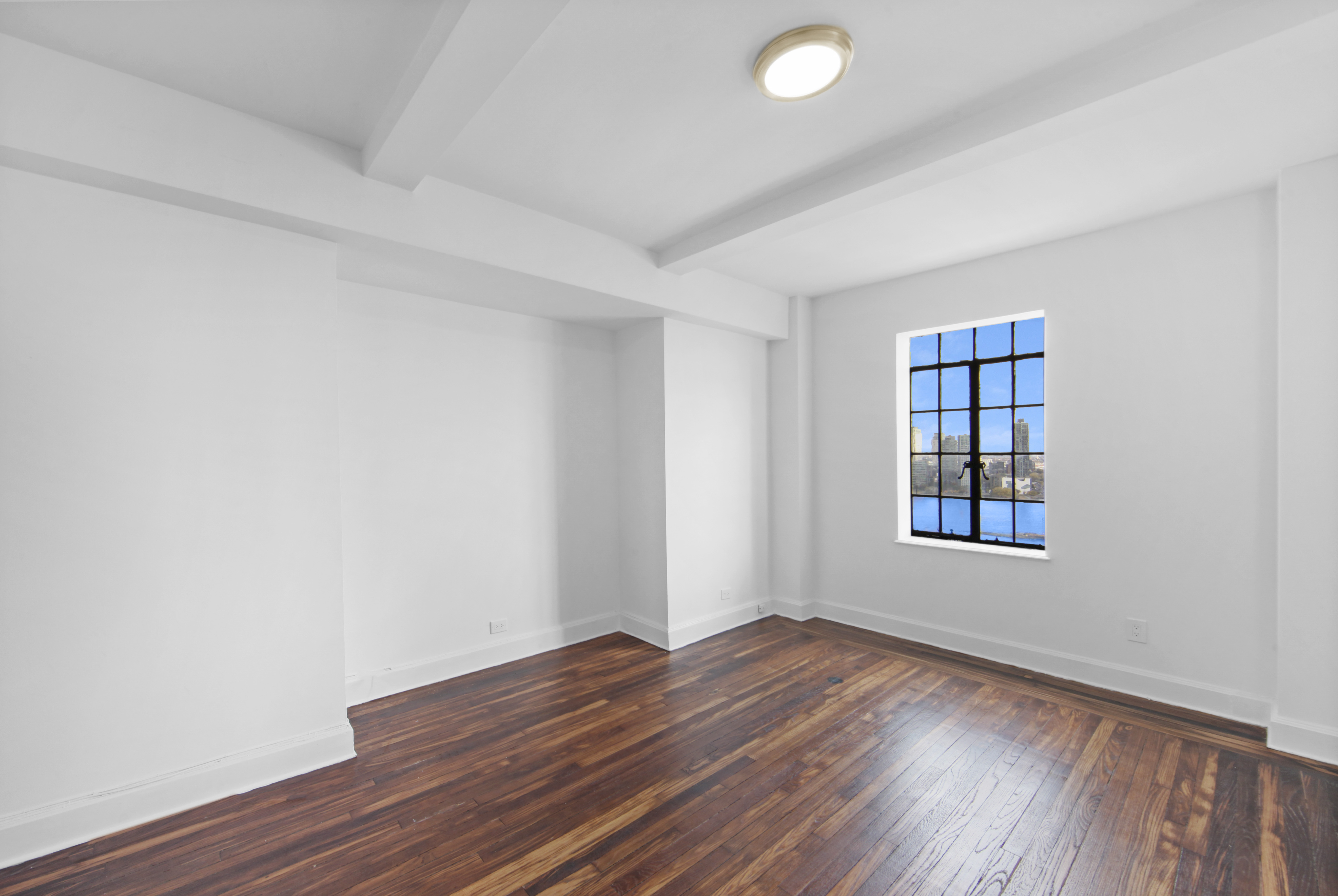 5 Tudor City Place, Unit 1536 Manhattan, NY 10017 - Photo 14 of 21 an empty room with wooden floor and windows