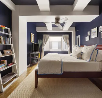 a bedroom with a bed a bookshelf and a book shelf