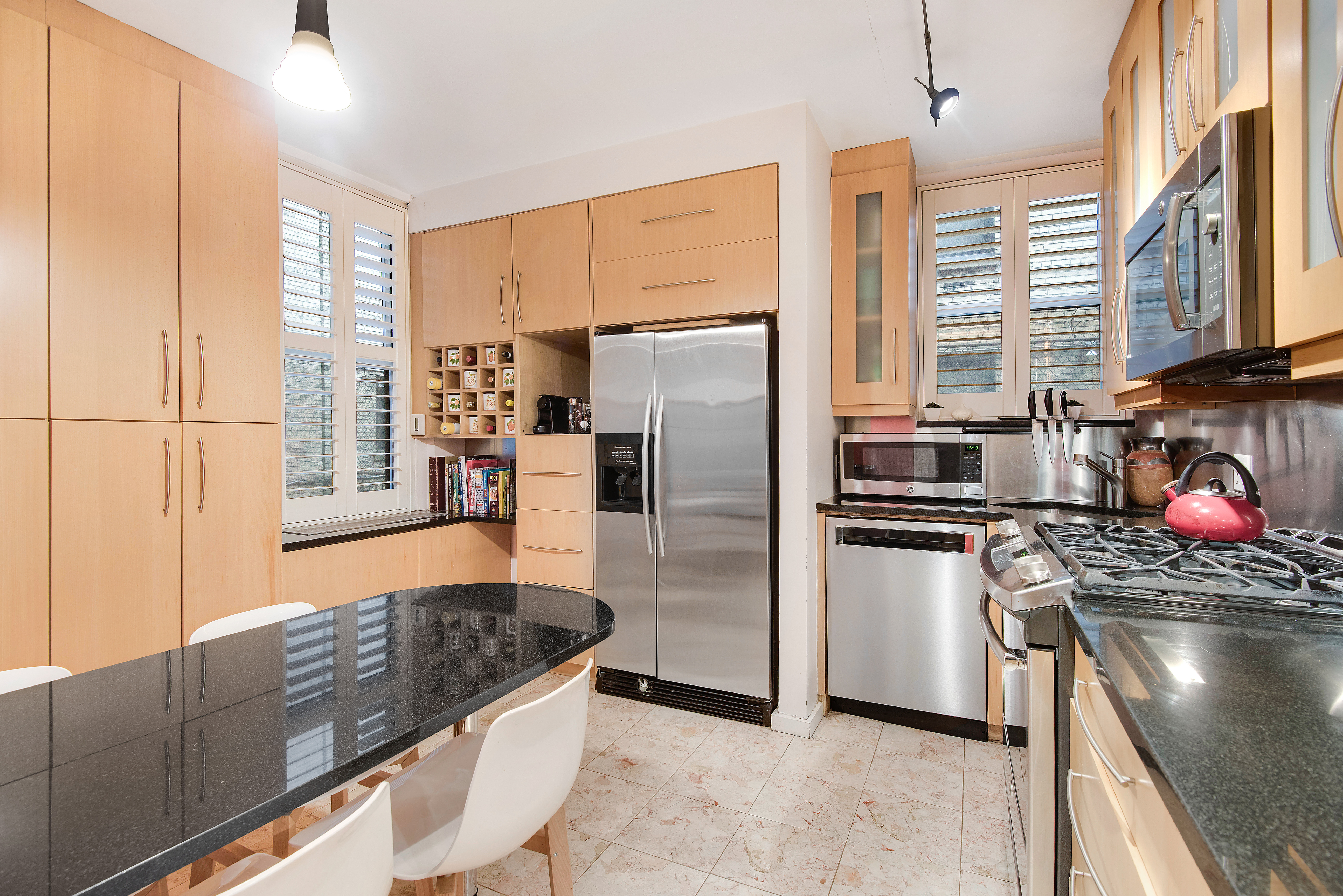 434 East 52nd Street, Unit 1BH Manhattan, NY 10022 - Photo 4 of 23 a kitchen with stainless steel appliances granite countertop a stove a sink and a refrigerator