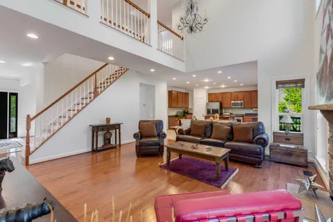 a living room with furniture kitchen view and a large window