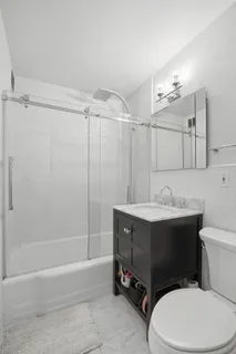a bathroom with a sink a toilet and shower