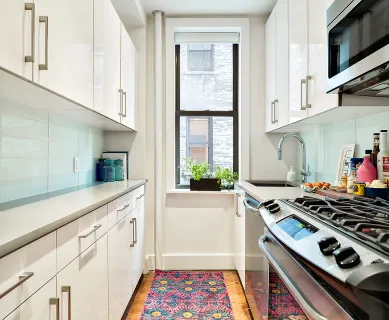 a kitchen with white cabinets and appliances