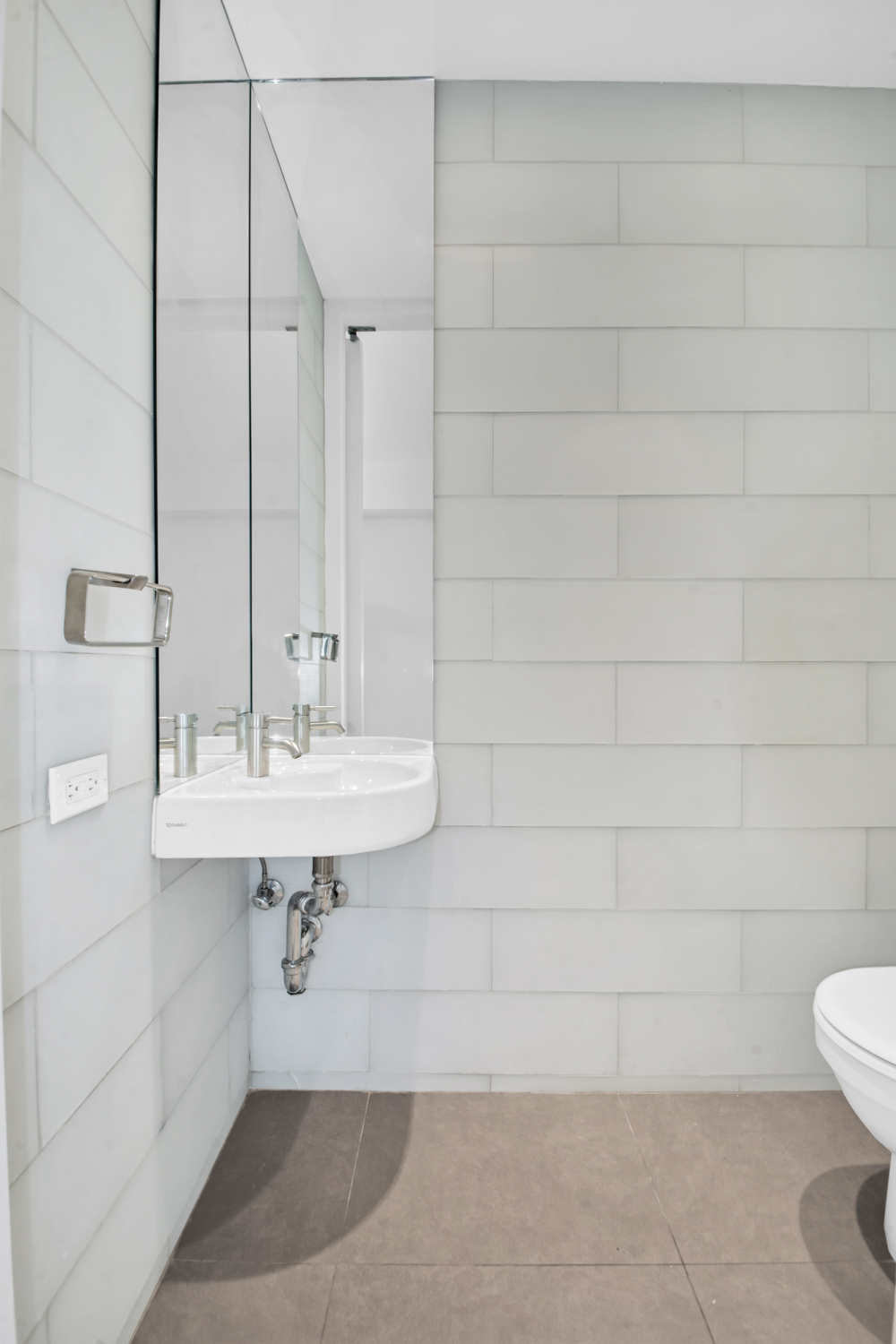 5 East 44th Street, Unit 5A Manhattan, NY 10017 - Photo 11 of 15 a bathroom with a sink a toilet and mirror