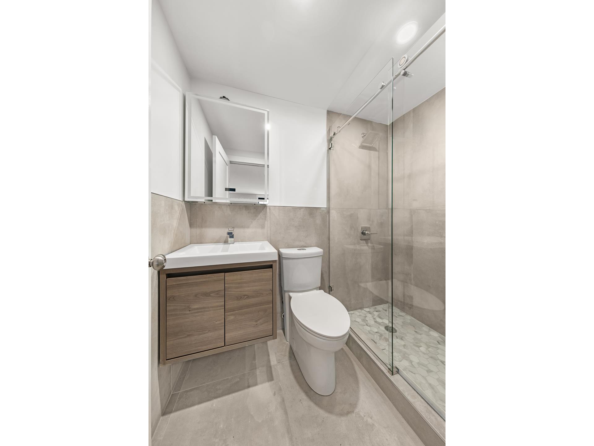227 East 21st Street, Unit 2F Manhattan, NY 10010 - Photo 6 of 7 a bathroom with a sink toilet and shower