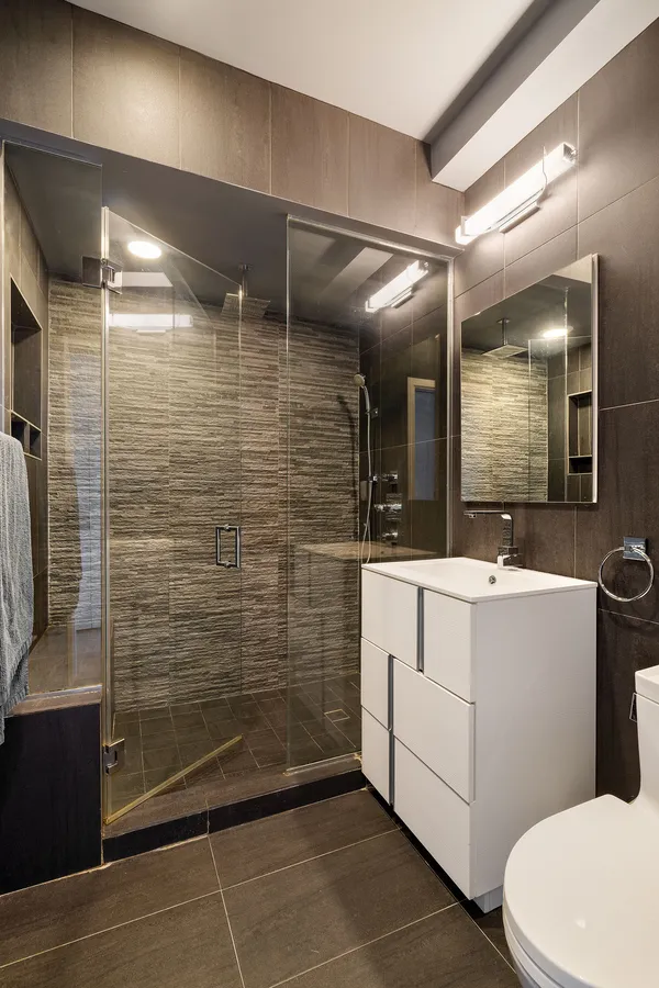 a bedroom with a bed a couch and three large window