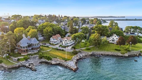 an aerial view of a house with a garden and lake view